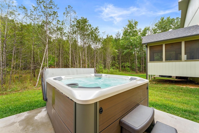 view of patio / terrace with a view of trees and a hot tub