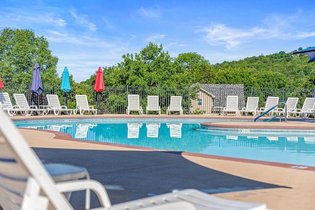 pool featuring fence and a patio