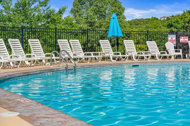 community pool featuring a patio area and fence