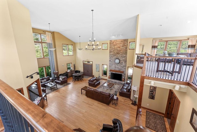 living room with a fireplace, a chandelier, wood finished floors, and high vaulted ceiling