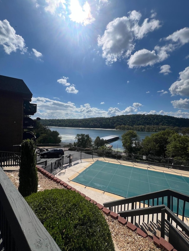 view of pool featuring a water view and a patio area