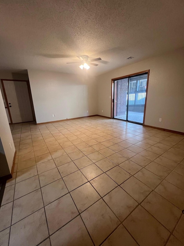 tiled spare room with ceiling fan and a textured ceiling