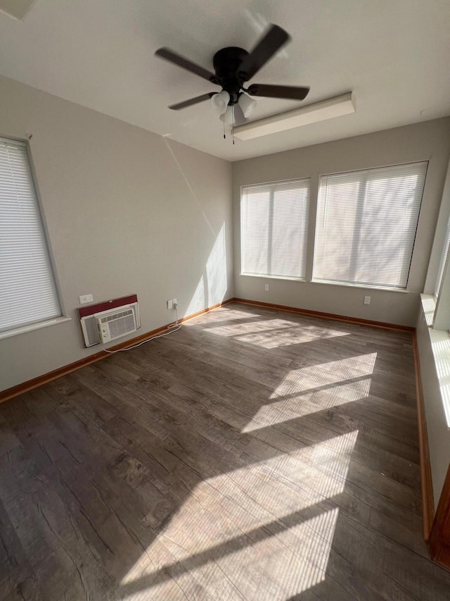 empty room with ceiling fan, dark hardwood / wood-style floors, and a wall unit AC