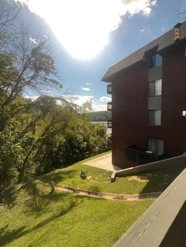 view of side of home featuring a patio and a lawn