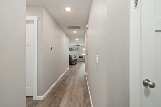 hallway featuring wood-type flooring and a textured ceiling