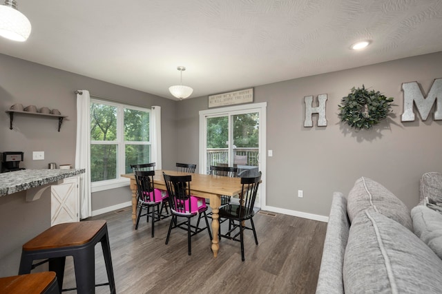 dining room with dark wood-type flooring and a wealth of natural light