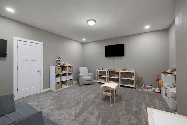 game room with a textured ceiling and carpet flooring