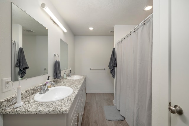 bathroom with hardwood / wood-style flooring, vanity, and a textured ceiling