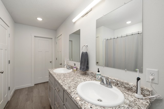 bathroom with hardwood / wood-style flooring, vanity, and walk in shower