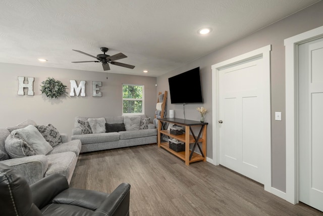 living room featuring ceiling fan and hardwood / wood-style floors