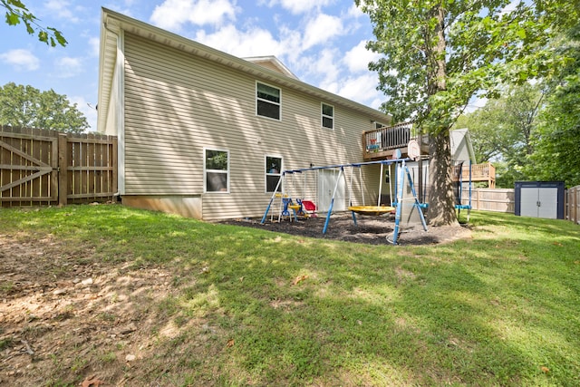 rear view of property featuring a shed, a yard, and a playground