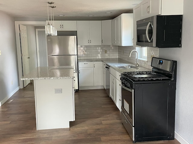 kitchen featuring white cabinets, stainless steel appliances, hanging light fixtures, and sink