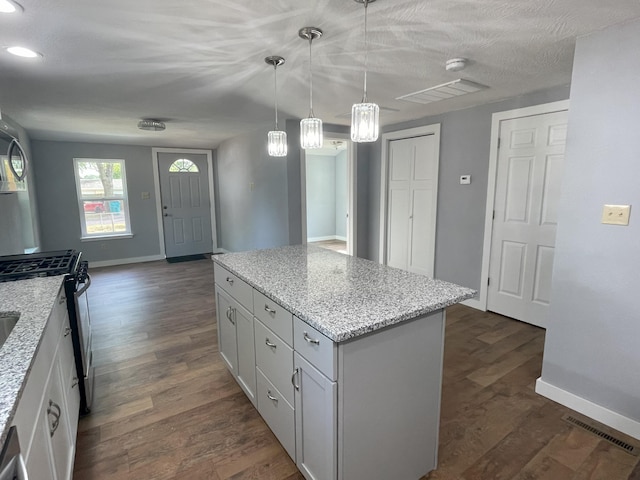 kitchen with dark hardwood / wood-style flooring, a center island, white cabinets, and pendant lighting