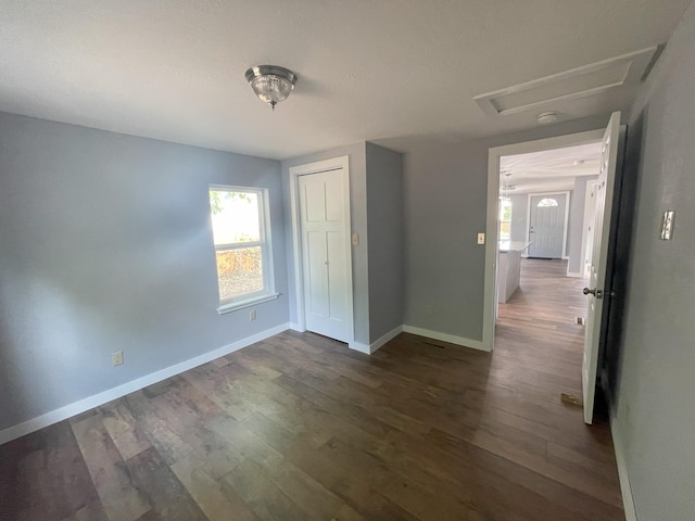 unfurnished bedroom with a closet and dark hardwood / wood-style floors