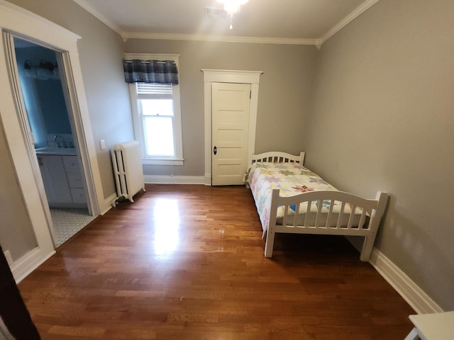 bedroom featuring ornamental molding, dark hardwood / wood-style flooring, and radiator