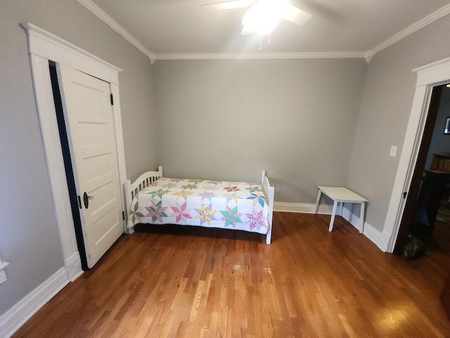 unfurnished bedroom with ceiling fan, ornamental molding, and hardwood / wood-style floors