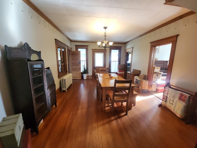 dining space with ornamental molding, an inviting chandelier, dark wood-type flooring, and radiator heating unit