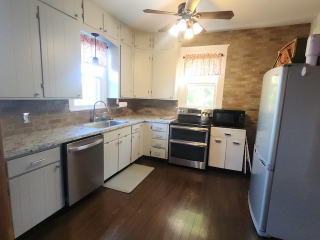 kitchen with appliances with stainless steel finishes, a healthy amount of sunlight, white cabinetry, and sink