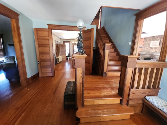 staircase featuring hardwood / wood-style floors and a notable chandelier