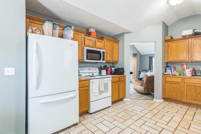 kitchen with brown cabinetry, lofted ceiling, brick floor, and white appliances