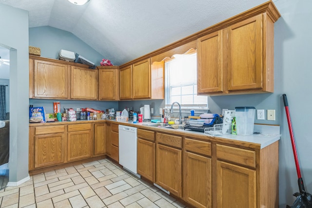 kitchen with lofted ceiling, sink, white dishwasher, light tile patterned floors, and a textured ceiling