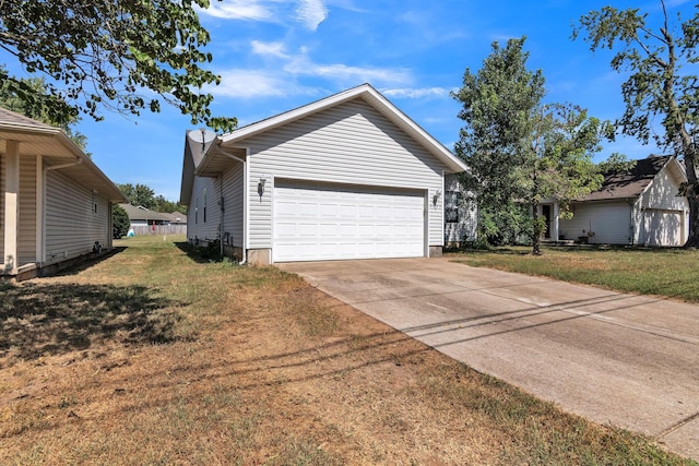 view of side of home featuring a garage and a lawn