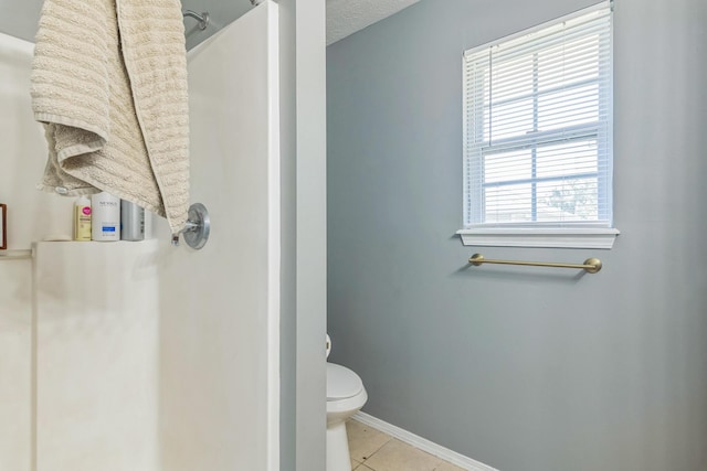 full bath with walk in shower, baseboards, tile patterned flooring, and toilet