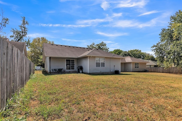 back of house featuring a lawn and a fenced backyard