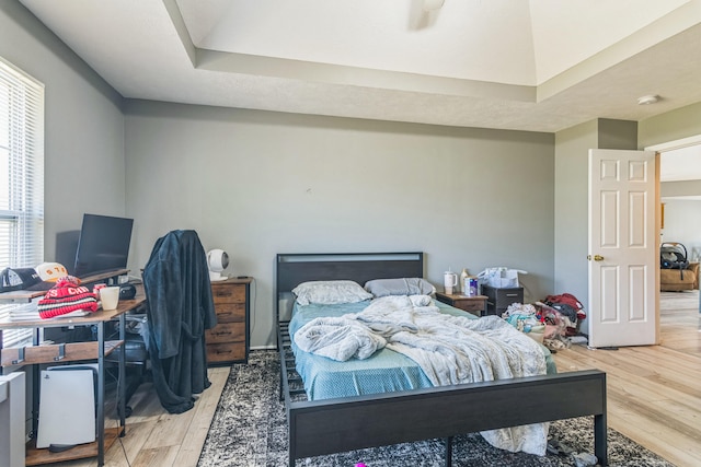 bedroom featuring ceiling fan, a tray ceiling, and hardwood / wood-style floors