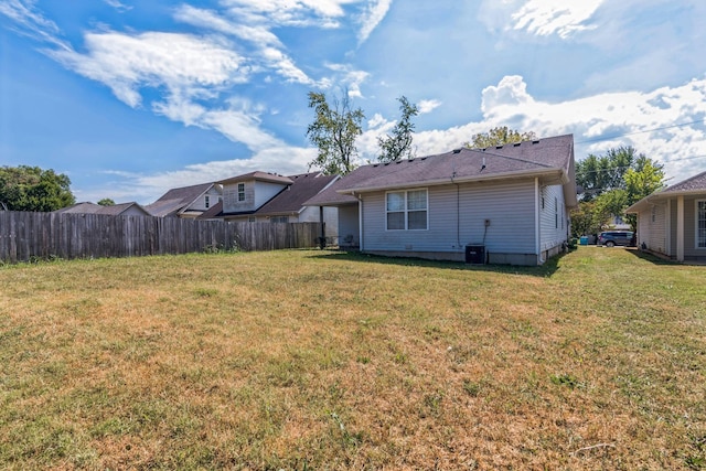 back of property with a yard and fence
