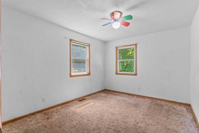 empty room with ceiling fan and carpet flooring