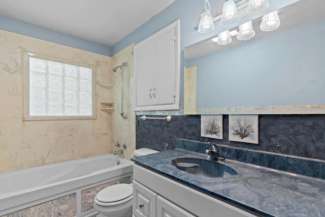 full bathroom featuring vanity, tiled shower / bath combo, and toilet