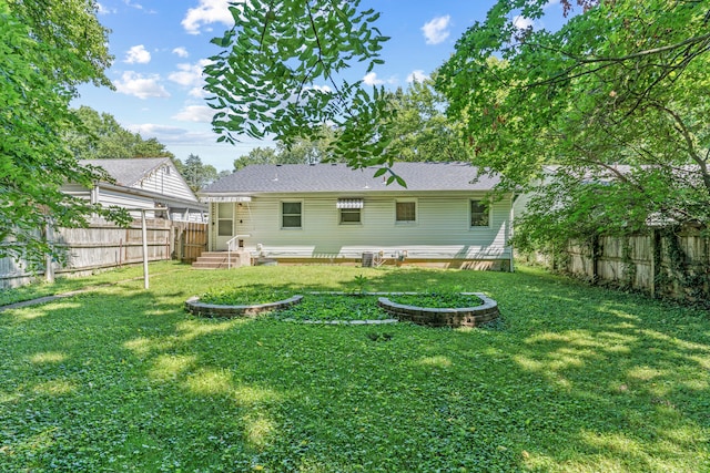 rear view of property featuring a lawn and an outdoor fire pit