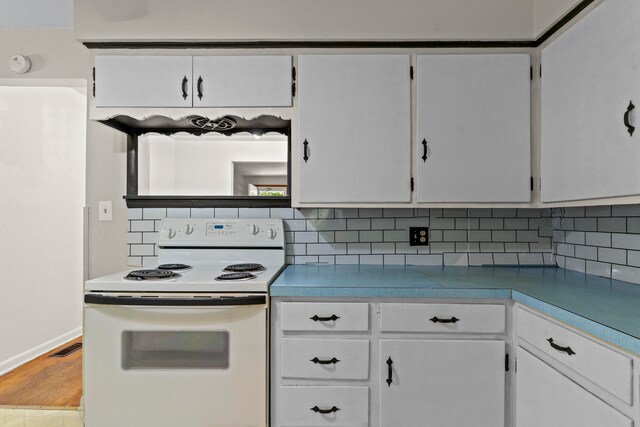 kitchen featuring tasteful backsplash, white cabinetry, and white electric range