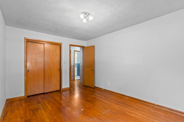 unfurnished bedroom featuring wood-type flooring and a closet