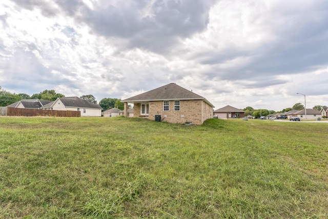 1130 S Arcadia Ave, Springfield, MO 65804 - back of house with fence, brick siding, and a yard