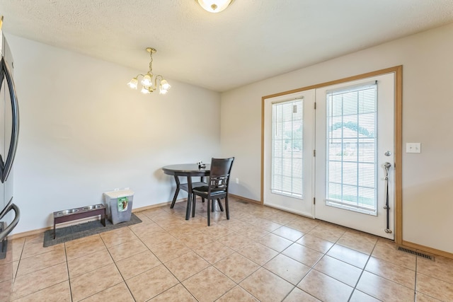 1130 S Arcadia Ave, Springfield, MO 65804 - dining room with a textured ceiling, a chandelier, light tile patterned floors, baseboards, and visible vents