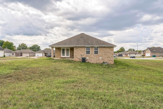 1130 S Arcadia Ave, Springfield, MO 65804 - rear view of property with a shingled roof, brick siding, a yard, and central AC unit