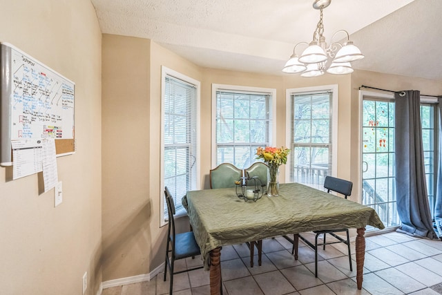 dining space with a textured ceiling, a chandelier, and light tile patterned floors