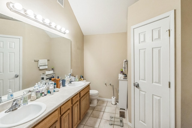 bathroom with tile patterned flooring, lofted ceiling, vanity, and toilet