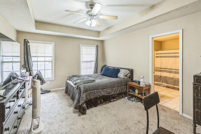 bedroom featuring a textured ceiling, ceiling fan, connected bathroom, and light colored carpet