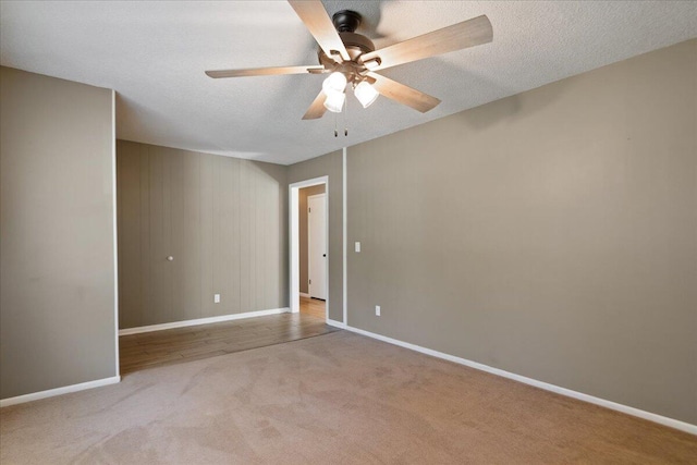 carpeted spare room featuring a textured ceiling and ceiling fan