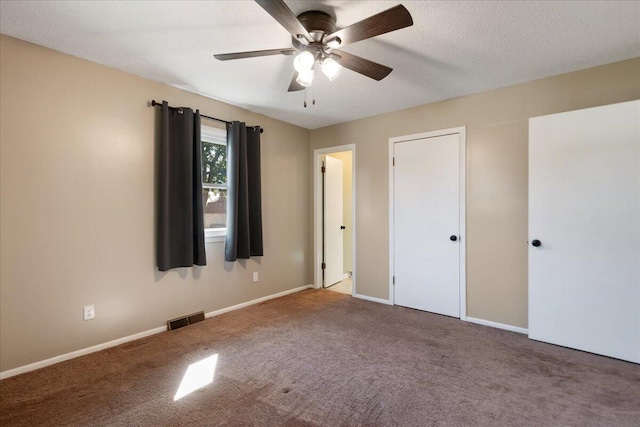 unfurnished bedroom with ceiling fan, carpet floors, and a textured ceiling