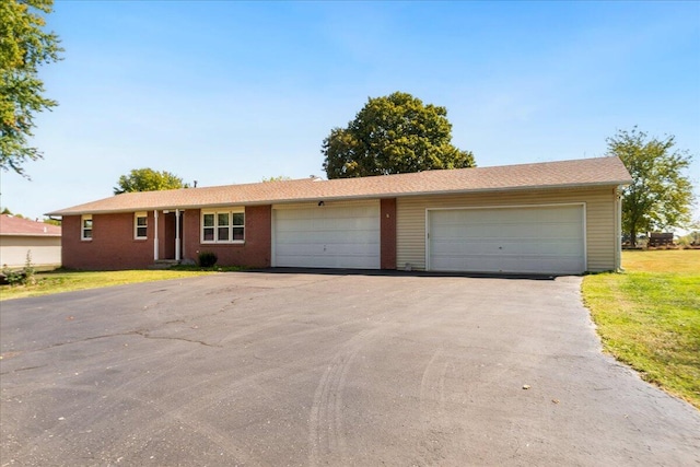 ranch-style house with a garage and a front lawn