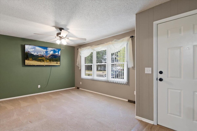 carpeted empty room featuring a textured ceiling and ceiling fan