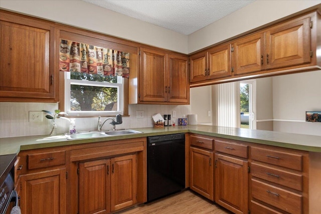 kitchen with light hardwood / wood-style floors, sink, dishwasher, kitchen peninsula, and a textured ceiling