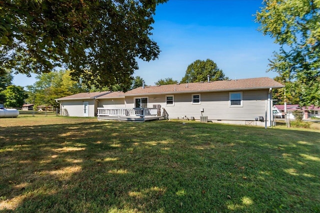 back of house with a shed, a yard, and a deck