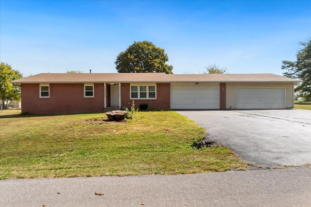 ranch-style house featuring a garage and a front lawn