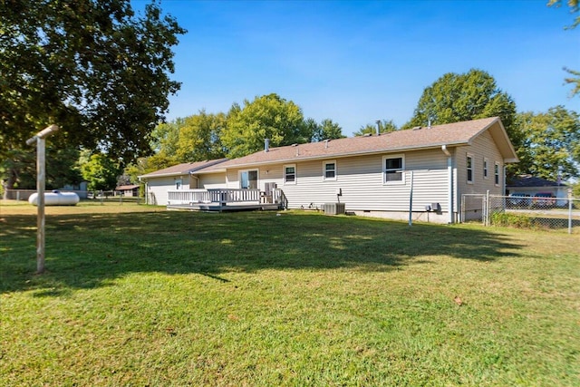 rear view of house featuring central AC unit, a deck, and a yard