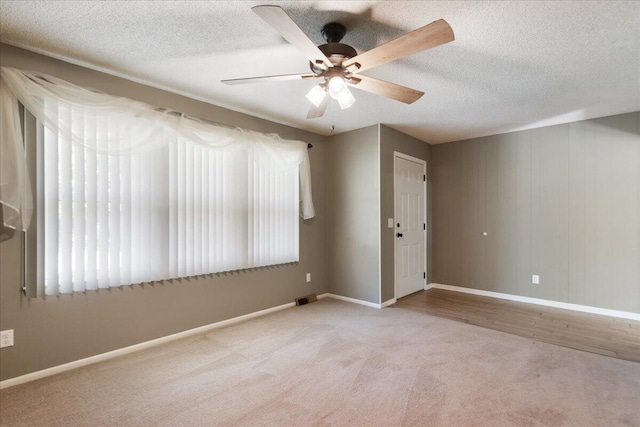 carpeted empty room featuring a textured ceiling and ceiling fan